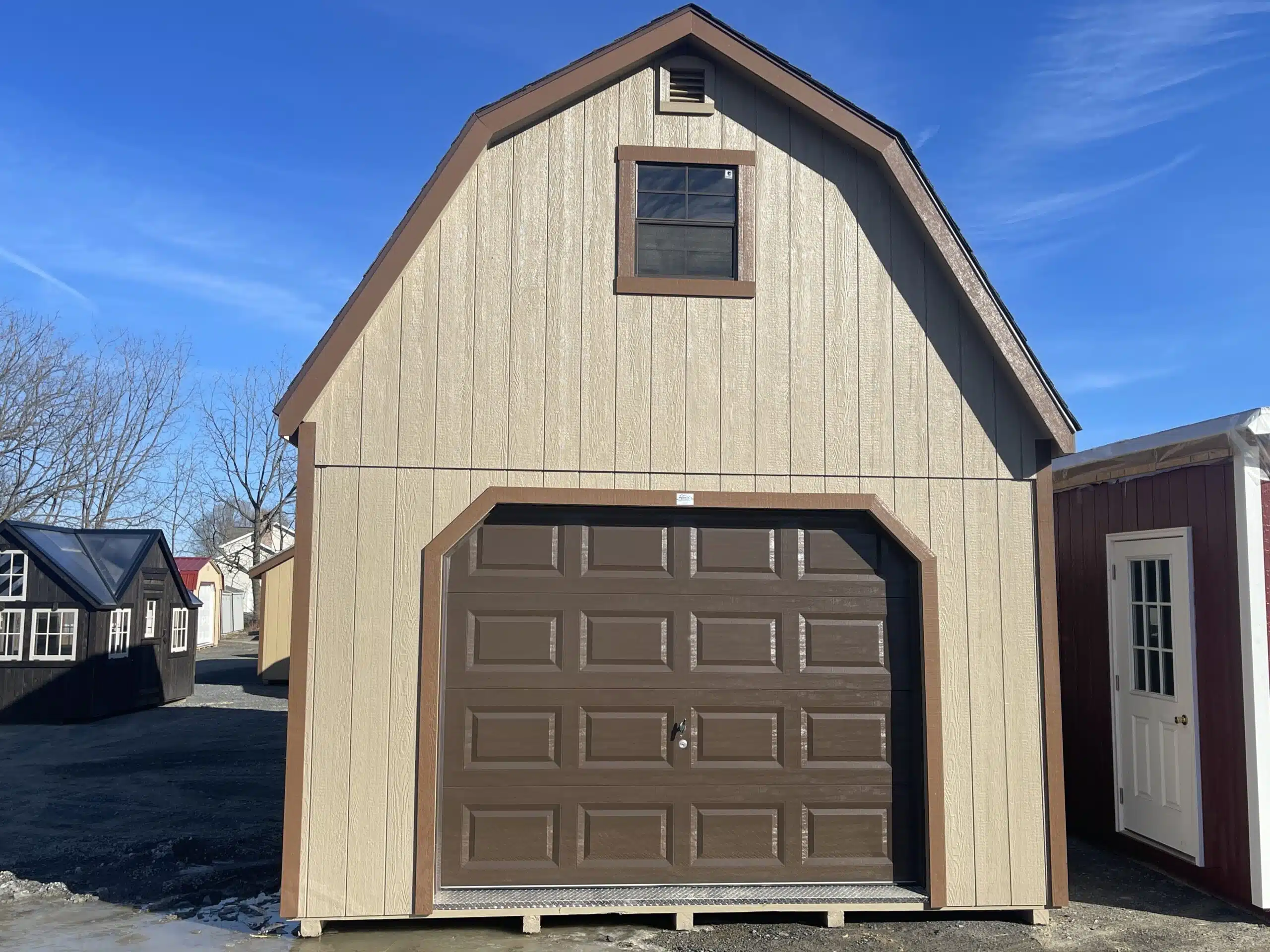 Front view of a 14x24 two-story garage with buckskin siding, chestnut trim, weatherwood shingle roof, brown garage door, and upper window.