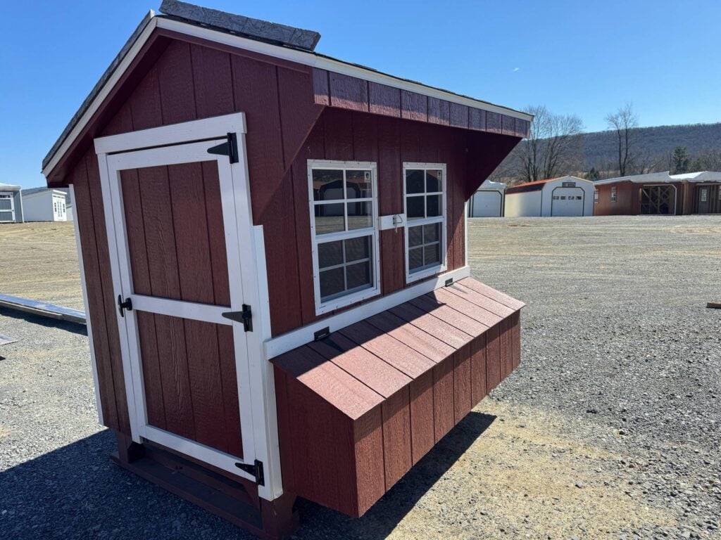 Stock Model 25S, a 4x6 chicken coop with Smartside painted in Shed Red, white trim, and a black architectural shingled roof. Features include a nesting box, secure locking chicken ramp, two windows, back vent, chicken roost, and a 3' access door for easy cleaning