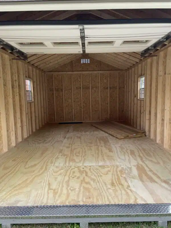 Rear and side view of a GP Clay Smartside A-frame garage with brown trim, driftwood roof, and a window with shutters.