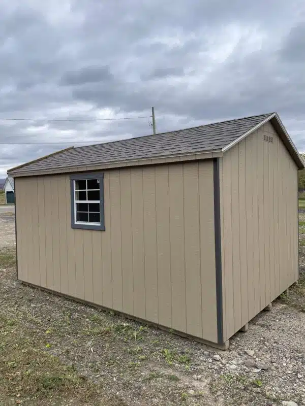 Rear and side view of a Gap gray Carolina Cottage shed with blue gray trim, charcoal roof, and a window with trim.