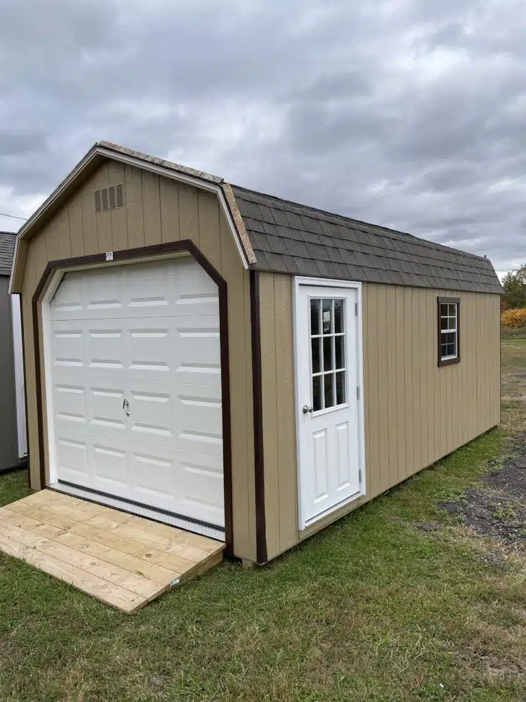 Basswood Smartside barn garage with brown trim, weatherwood roof, white 8x7 garage door, 9-lite entry door, window with trim, and wooden ramp.