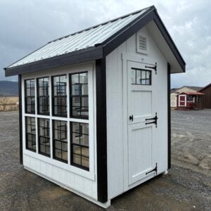 Side exterior view of 6x8 Legend Greenhouse model 2042S in white with black corners and black roof trim