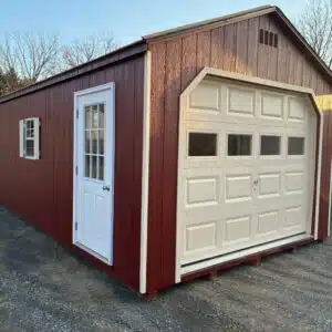 Red 12x24 A-Frame Garage with almond 9x7 garage door with lites, almond 9-lite prehung entry door, black roof, and side window with shutters.