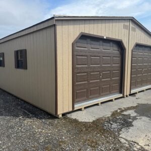 Buckskin 24x24 double garage with brown trim, weatherwood roof, two brown 9x7 garage doors, brown windows with shutters, ridge vent, and end vents shown from the front-side angle.
