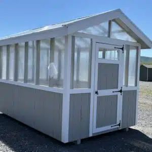8x12 Everleaf greenhouse in Gap Gray with white trim, clear roof panels, and a 3 foot transom door