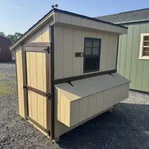 Used 4x6 lean-to chicken coop in tan with brown trim, showing access door, window, and nesting box.