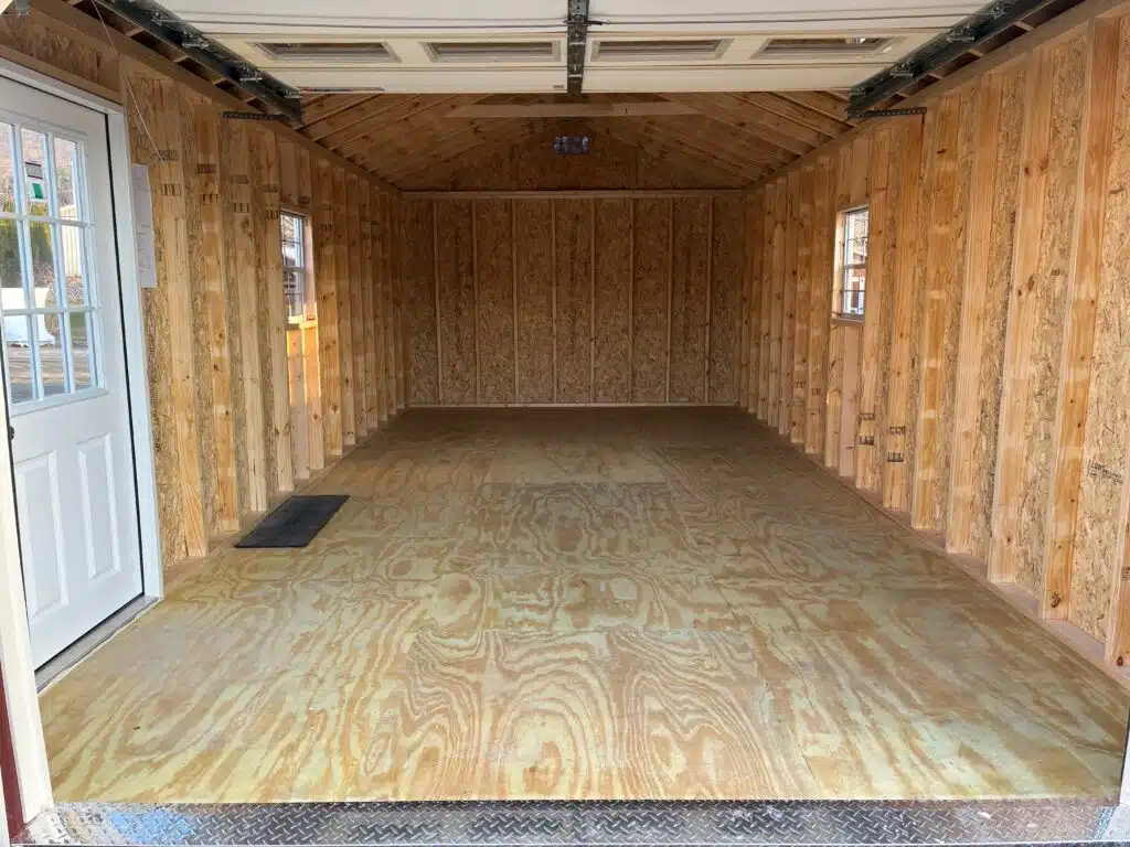 Front view of a 12x24 A-Frame garage with an almond 9x7 garage door, red siding, and almond trim