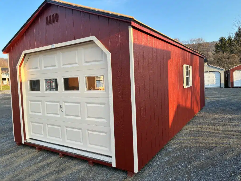 Inside of a 12x24 A-Frame garage showing open floor space, framed walls, and overhead garage door tracks