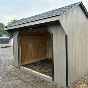 Angled view of a 10x12 horse run-in shelter with open front, Barnwood Gray siding, and black trim