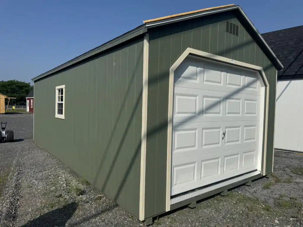 Side/front view of a 12x24 A-frame garage in Pequea Green with GP Almond trim and a white 9x7 garage door.