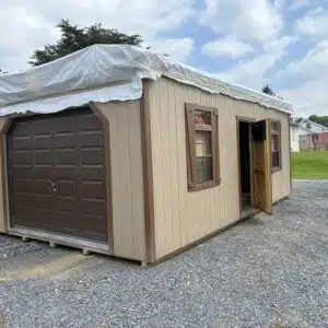 14x24 2-story barn garage with tan siding, brown trim, 9x7 brown garage door, and side entry door