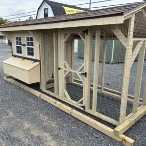 Chicken coop with enclosed 8-foot run, wire mesh walls, and access door in Stoltzfus Tan